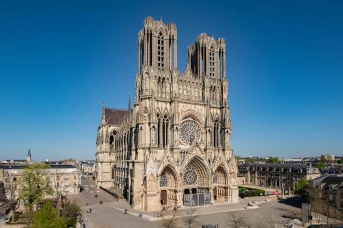 a large cathedral building with a tall tower at Le Loft de la Porte de Mars - à 5 min de la gare in Reims