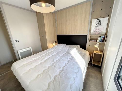 - une chambre avec un grand lit blanc dans l'établissement Chalet standing avec piscine chauffée, proche plage et commerces, équipé de WiFi - 6 couchages. - FR-1-361-513, à Jullouville