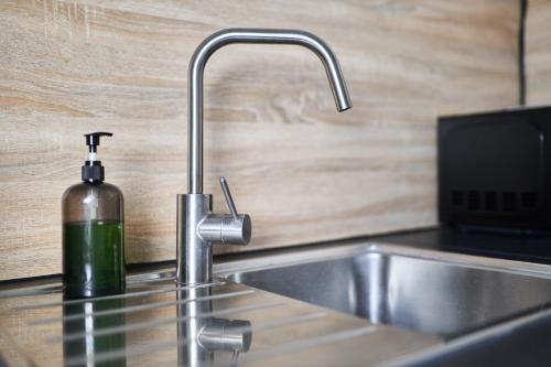 a kitchen sink with a soap bottle next to it at Le Loft de la Porte de Mars - à 5 min de la gare in Reims