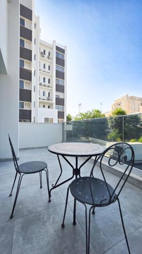 a table and two chairs sitting on a balcony at Poolside Lux Apartment in Larnaca