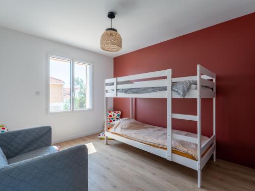 a bedroom with a bunk bed and a red wall at Maison neuve climatisée, 8 pers, proche plages, surf, Wi-Fi, terrasse, parking, ménage inclus - FR-1-319-526 in Biscarrosse