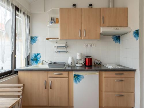 a kitchen with wooden cabinets and a sink at Appartement pour 3 à Mimizan Plage, à 50m de l'océan avec terrasse et parking, ménage inclus - FR-1-50-123 in Mimizan