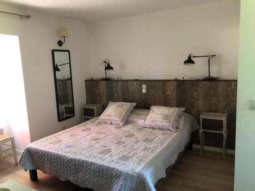 a bedroom with a large bed with a wooden headboard at Gite Roche Blanche in Lolme