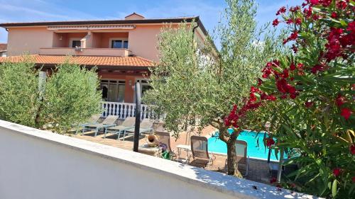 a villa with a swimming pool and a house at Apartments Kimm's Hideaway in Poreč