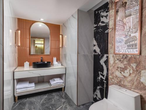 a bathroom with a sink and a toilet and a mirror at Pipa Hotel Bangkok Sukhumvit 11 in Bangkok