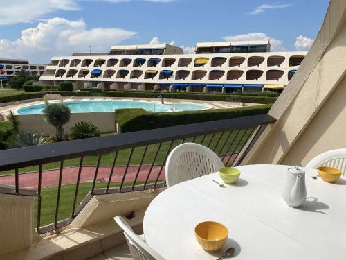d'une table et de chaises sur un balcon avec piscine. dans l'établissement Studio 4 pers avec piscine et terrasse, Port Camargue - FR-1-250-167, au Grau-du-Roi