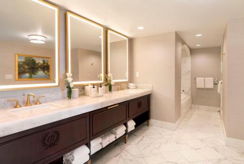 a bathroom with two sinks and a large mirror at Willard InterContinental Washington by IHG in Washington