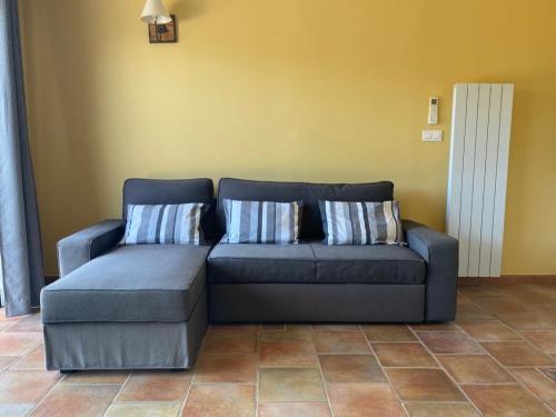 a blue couch with two pillows in a living room at Mas de Cala, gîtes détente au Pic Saint Loup in Saint-Mathieu-de-Tréviers