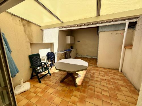 une chambre avec une table et des chaises dans un garage dans l'établissement Maison T3 avec cour close, proche plage et commerces, quartier Arago, Les Sables-d'Olonne - FR-1-92-657, à Les Sables-dʼOlonne
