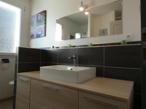 une salle de bain avec un lavabo blanc et un miroir dans l'établissement Appartement moderne 68m² à Notre-Dame-de-Monts, 6 pers, accès PMR, terrasse, proche forêt et plages - FR-1-540-277, à Notre-Dame-de-Monts