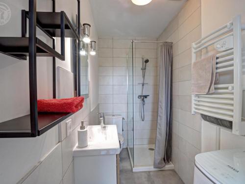 un bagno bianco con lavandino e doccia di Appartement T2 avec terrasse, parking et wifi à St-Genest-Lerpt - FR-1-496-287 a Saint-Genest-Lerpt