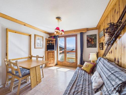 une salle à manger avec une table et une table à manger dans l'établissement Studio cabine 4/5 pers avec parking, au pied des pistes de la Rosière - FR-1-398-658, à Montvalezan