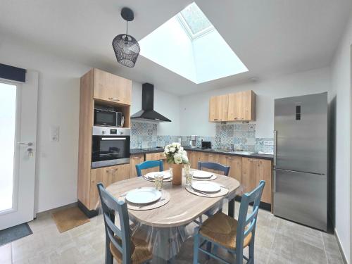 une cuisine avec une table et des chaises et une cuisine avec une fenêtre dans l'établissement Appartement neuf 62 m², 5 couchages, à 250 m de la plage - balcon, jardin privé, et parking inclus - FR-1-364-111, à Saint-Brévin-les-Pins