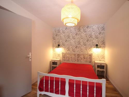 une chambre avec un lit blanc avec une couverture rouge dans l'établissement Charmant F2 bis au Mont-Dore avec balcon, au pied des pistes, 6 pers, parking, ascenseur - FR-1-415-150, à Le Mont-Dore