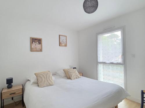 une chambre blanche avec un lit et une fenêtre dans l'établissement Appartement neuf 62 m², 5 couchages, à 250 m de la plage - balcon, jardin privé, et parking inclus - FR-1-364-111, à Saint-Brévin-les-Pins