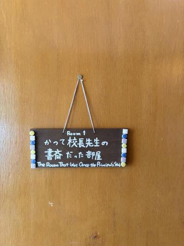 a sign hanging on a wall with writing on it at Vineyard Vista ENZAN in Koshu