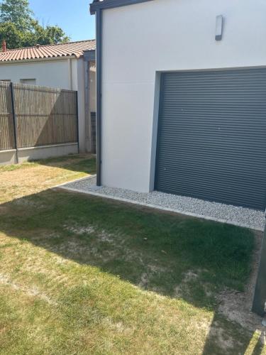 a garage door on the side of a house at Studio cosy et indépendant - idéal pour 2 personnes in Dompierre-sur-Yon