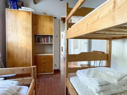 une chambre avec deux lits superposés et une étagère dans l'établissement Maison 4 pièces près mer et port La Palmyre - 7 pers., WiFi, animaux OK, parking, patio, ménage inclus - FR-1-705-36, aux Mathes
