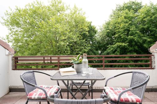 a patio table with two chairs and a bottle of wine at Waldstraße 2 Kellenhusenliebe in Kellenhusen