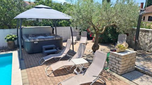 a group of chairs and an umbrella next to a pool at Apartments Kimm II in Poreč