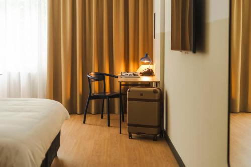 a hotel room with a desk with a bed and a table at Hotel Node 