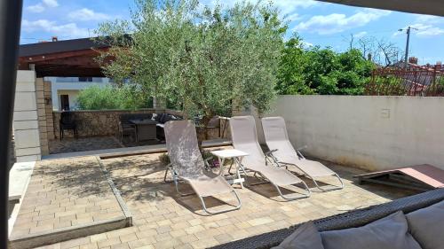 a group of chairs and a table on a patio at Apartments Kimm II in Poreč