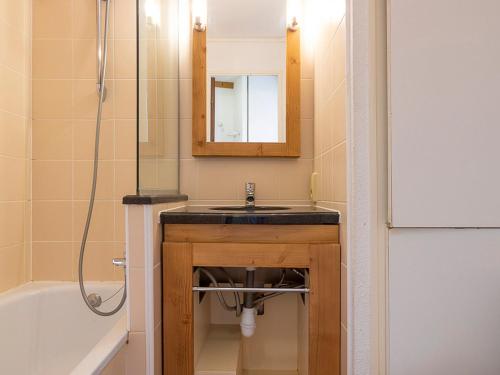 une salle de bain avec un lavabo, une baignoire et un miroir dans l'établissement Charmant 2 pièces 5 pers, proche centre, pistes et luge, avec balcon sud, Wi-Fi et casier à ski - FR-1-314-263, à Morzine