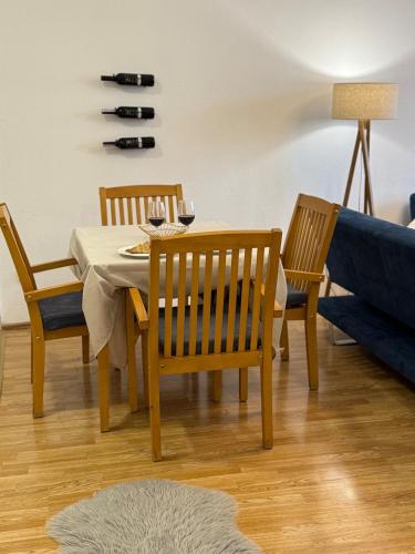 a dining room with a table and chairs and a couch at Cozy Central Apartment in Gjakove