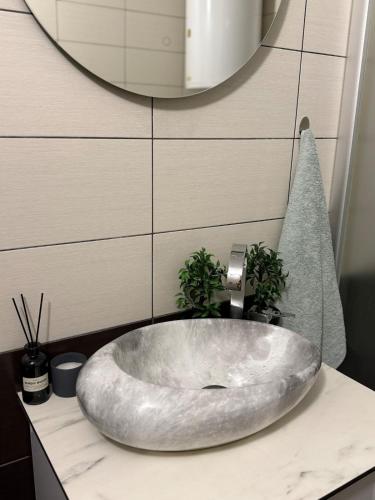 a bathroom sink with a large silver bowl at Cozy Central Apartment in Gjakove