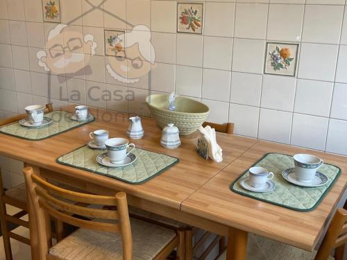 a wooden table with cups and saucers on it at La Casa dei Nonni in Bracciano