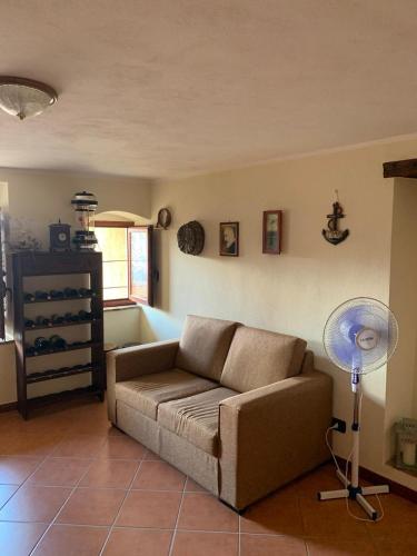 a living room with a couch and a floor fan at Ophi House in Badolato