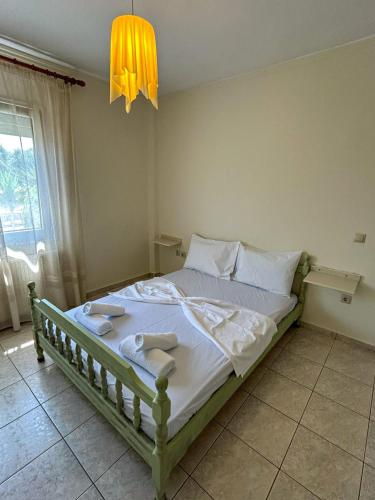 a bedroom with a bed with white sheets and a chandelier at Limenas Smart Stay in Limenas