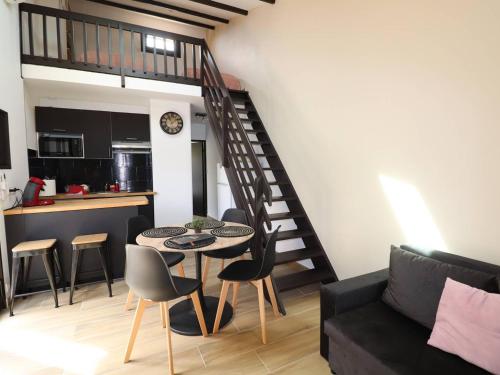 un salon avec une table et des chaises et un escalier dans l'établissement Maison clim. proche mer, terrasse et parking privatisé, 6 pers. - FR-1-307-230, au Grau-du-Roi
