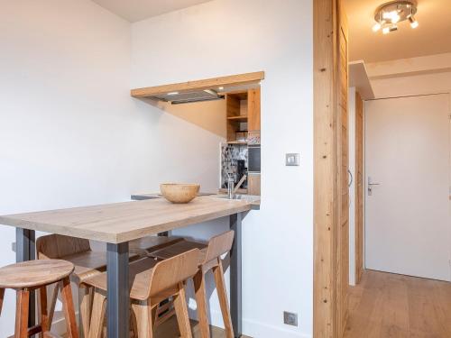 une cuisine avec une table et des chaises en bois dans l'établissement Charmant 2 pièces rénové, internet fibre, balcon, casier à ski, quartier paisible - FR-1-314-210, à Morzine