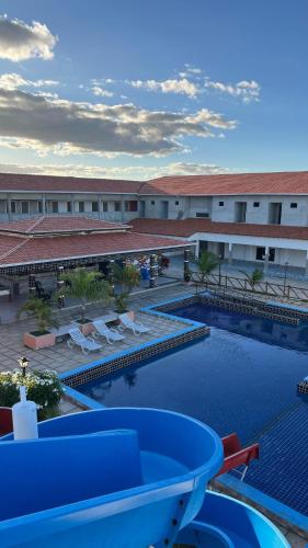 a swimming pool with chairs and a building at Hotel Acqua Park in Capim Grosso