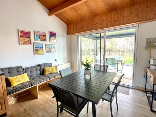 un salon avec une table et un canapé dans l'établissement Maison Cosy à La Sauzaie avec Jardin Clôturé, Pergola Bioclimatique et WIFI - FR-1-231-314, à Bretignolles-sur-Mer