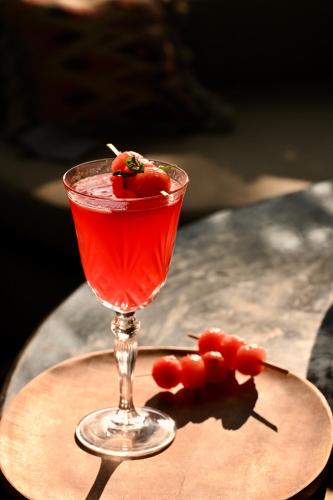 a red drink in a glass on a table at Romeo Lane Mussoorie - The Courtyard House in Mussoorie