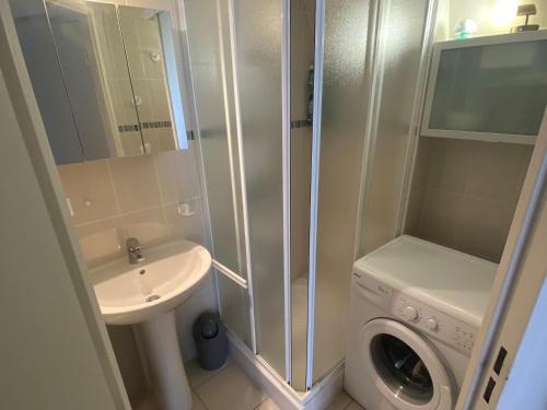 une salle de bain avec un lavabo et une machine à laver dans l'établissement Maisonnette avec Piscine, Terrasse et Jardin Privé - La Faute-sur-Mer - FR-1-194-282, à La Faute-sur-Mer