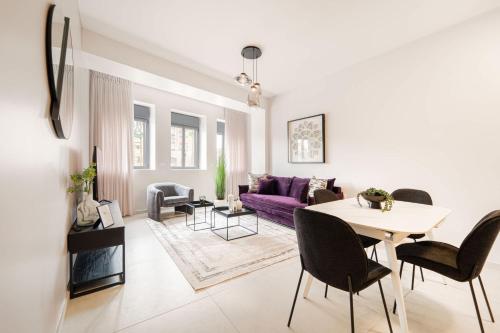 Una sala de estar con un sofá morado y una mesa. en Dreamy 1Bdr Sanctuary In The Heart Of Jerusalem, en Jerusalén