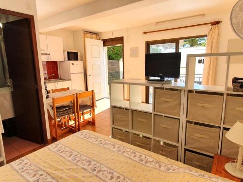 une chambre avec un lit et une cuisine avec une télévision dans l'établissement Studio avec coin-nuit, piscine, terrasse et parking à Sainte-Maxime, proche plages et commerces - FR-1-780-74, à Sainte-Maxime
