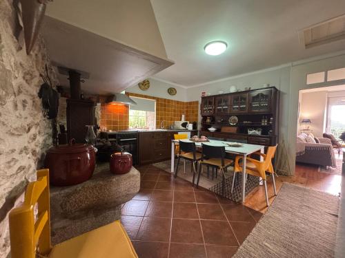 a kitchen and dining room with a table and chairs at Casa da Avó Quina - Seixas in Coura