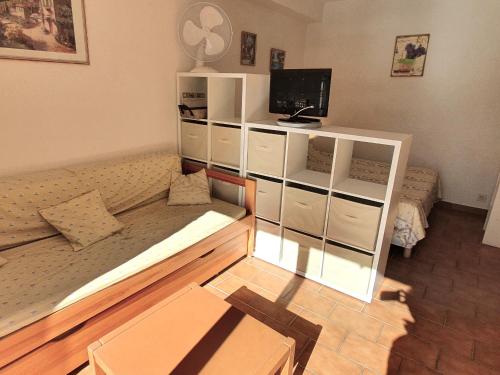 un salon avec un canapé et une télévision dans l'établissement Studio avec coin-nuit, piscine, terrasse et parking à Sainte-Maxime, proche plages et commerces - FR-1-780-74, à Sainte-Maxime