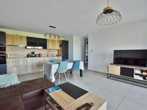 un salon et une cuisine avec un canapé et une table dans l'établissement Appartement neuf moderne avec balcon et garage à Évian - FR-1-498-103, à Évian-les-Bains