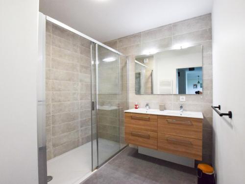 une salle de bain avec une douche, un lavabo et un miroir dans l'établissement Appartement neuf moderne avec balcon et garage à Évian - FR-1-498-103, à Évian-les-Bains