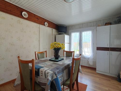 une cuisine avec une table avec un vase de fleurs dessus dans l'établissement Charmant Studio à La Faute-sur-Mer, proche plages et commerces, idéal pour 2 pers. - FR-1-476-210, à La Faute-sur-Mer