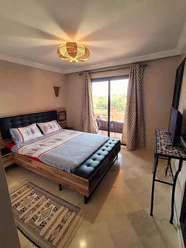a bedroom with a large bed and a window at L'ECRIN de la PALMERAIE in Dar Caïd Layadi
