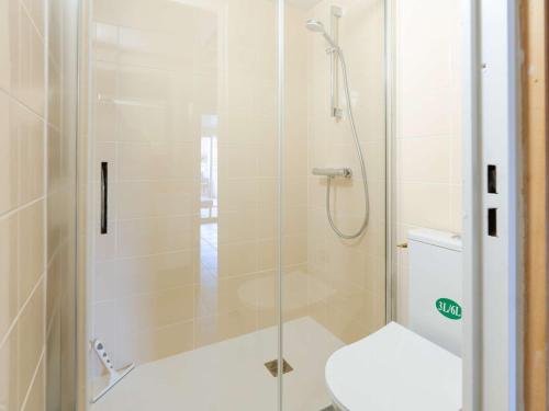 une douche avec une porte vitrée à côté des toilettes dans l'établissement Pavillon Studio Mezzanine Climatisé avec Piscine et WIFI, Proche Plage à Gruissan - FR-1-409-240, à Gruissan