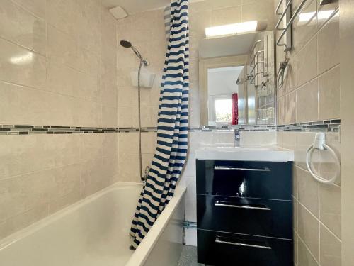 une salle de bain avec un lavabo, une baignoire et un miroir dans l'établissement Maisonnette 4 pers. à 300m de la Plage avec Piscine, Tennis et WIFI - FR-1-231-321, à Bretignolles-sur-Mer