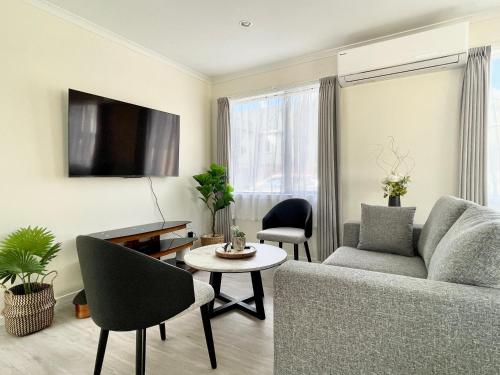 a living room with a couch and a table at S&N modern 2 bedrooms house opposite Waikato Hospital in Hamilton