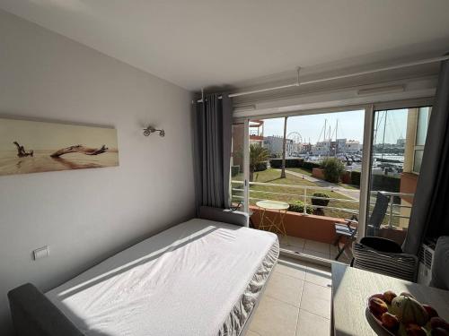 une chambre avec un lit et une grande fenêtre dans l'établissement Studio centre Cap d'Agde avec parking privé - FR-1-723-25, au Cap d'Agde